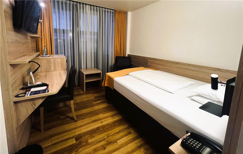 Comfort single room with single bed, desk, spacious wardrobe, wall mirror, seating, TV, bathroom