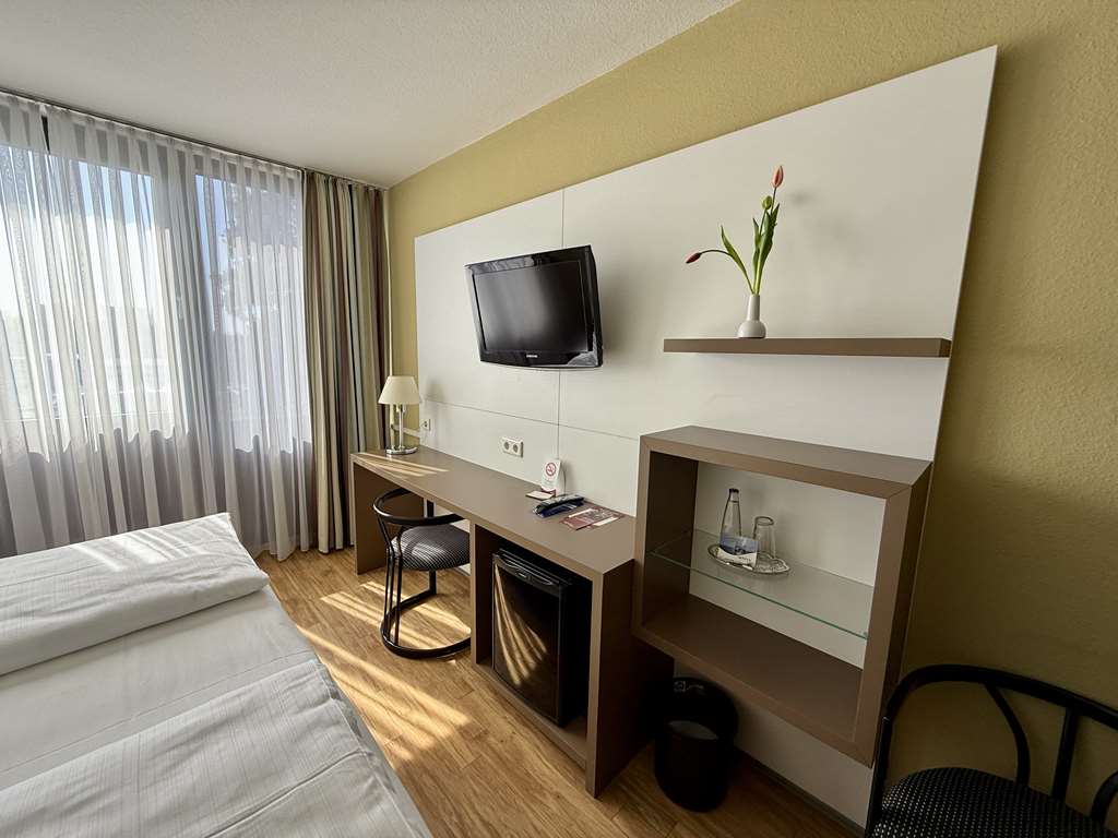 Comfort double room with double bed, desk, spacious wardrobe, wall mirror, seating, TV, bathroom