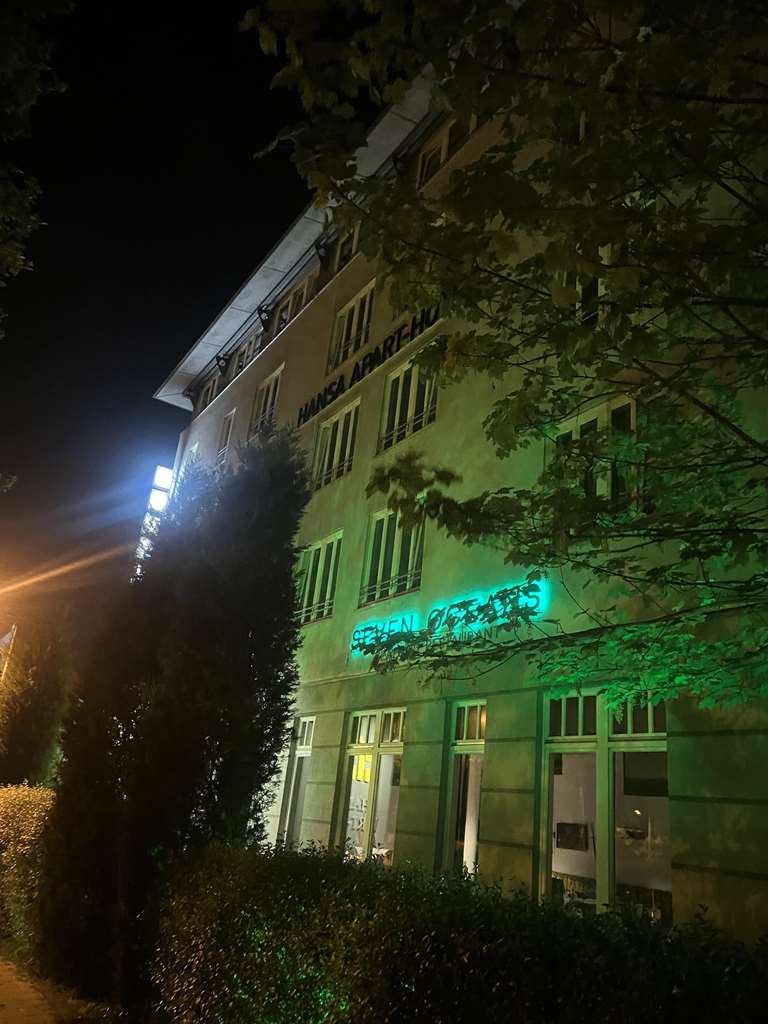 The exterior view of the Hansa Apart-Hotel at night.