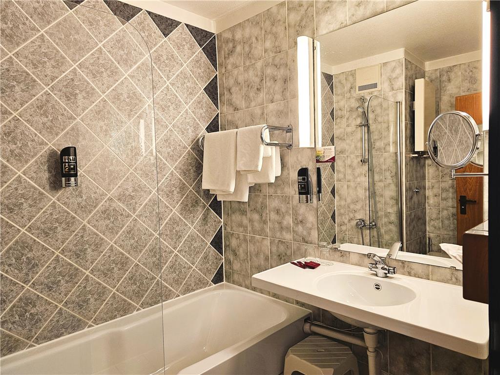 Bathroom with bathtub/shower combination, WC, washbasin, make-up mirror, hairdryer, toiletries and care products