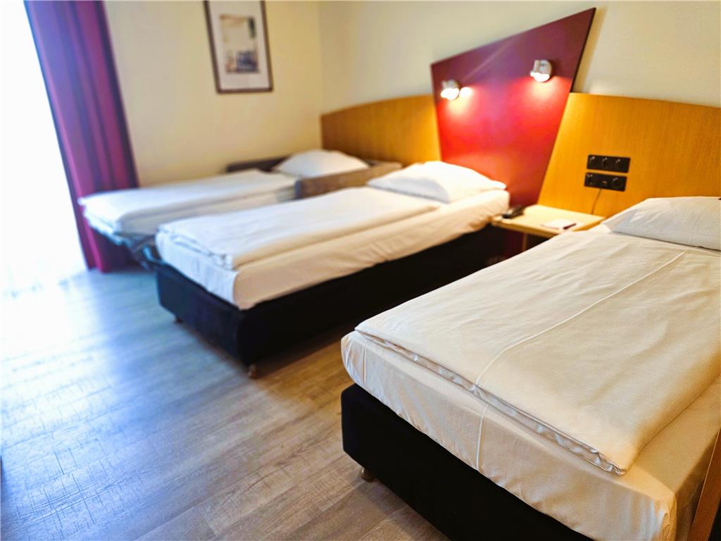 Comfort triple room with double bed and sofa bed, desk, spacious wardrobe, wall mirror, seating, TV, bathroom
