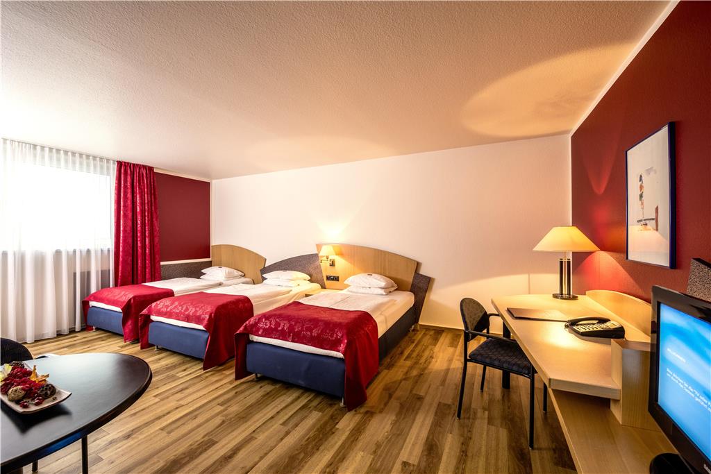 Comfort triple room with three single beds, desk, spacious wardrobe, wall mirror, seating, TV, bathroom