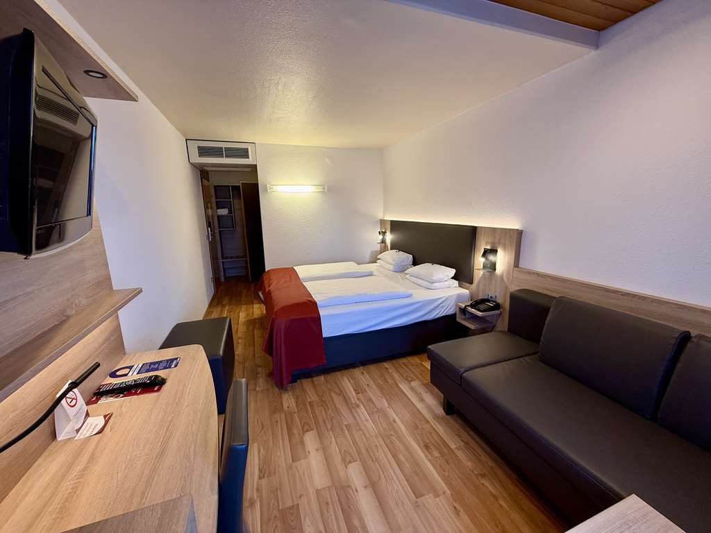 Comfort double room with queen-size bed, desk, spacious wardrobe, wall mirror, seating, TV, bathroom