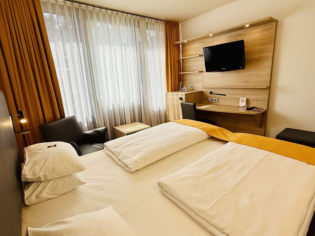Comfort double room with queen-size bed, desk, spacious wardrobe, wall mirror, seating, TV, bathroom
