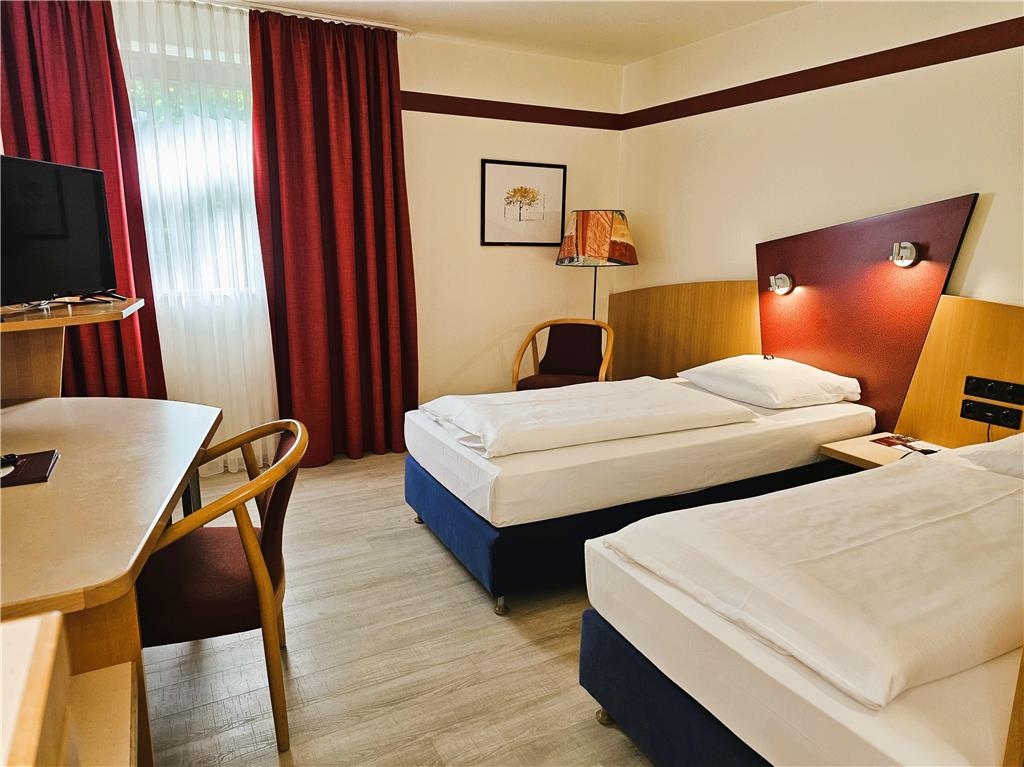 Comfort double room with twin beds, desk, spacious wardrobe, wall mirror, seating, TV, bathroom