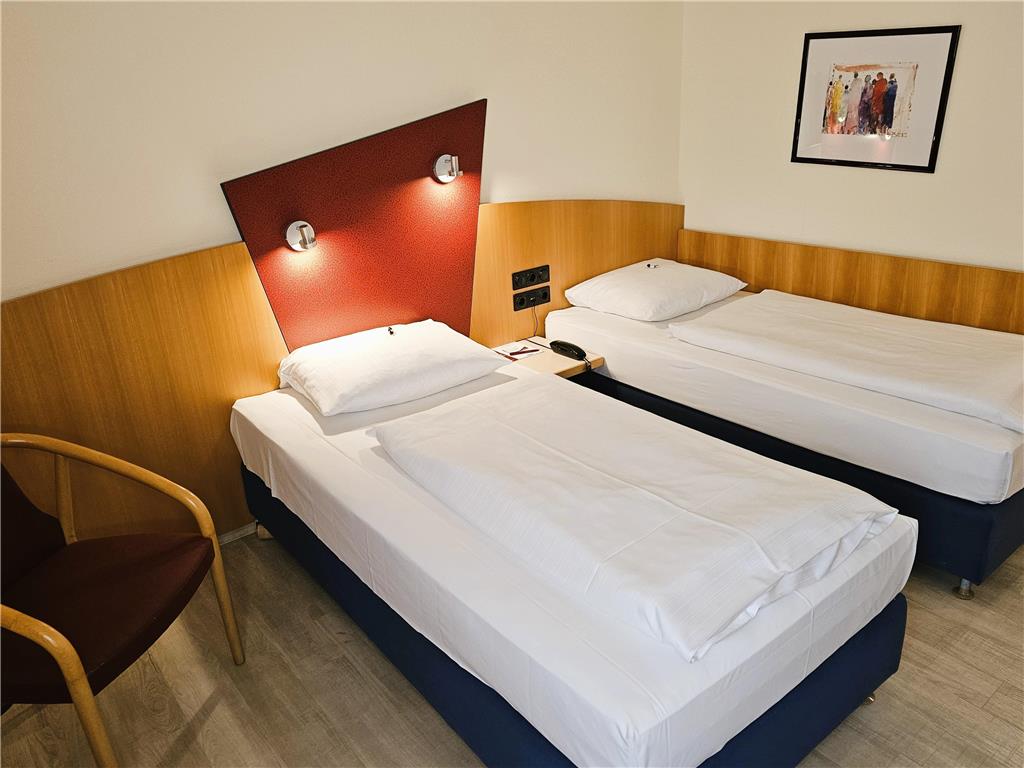 Comfort double room with twin beds, desk, spacious wardrobe, wall mirror, seating, TV, bathroom
