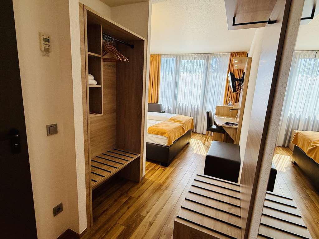 Comfort double room with queen-size bed, desk, spacious wardrobe, wall mirror, seating, TV, bathroom