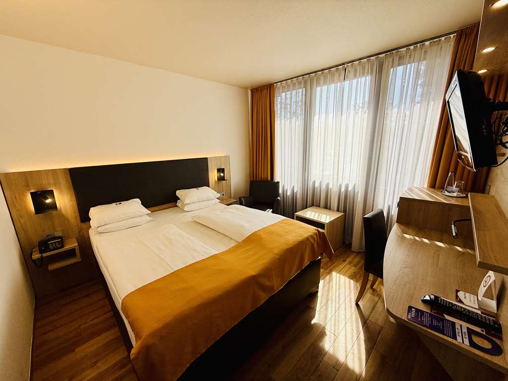 Comfort double room with queen-size bed, desk, spacious wardrobe, wall mirror, seating, TV, bathroom