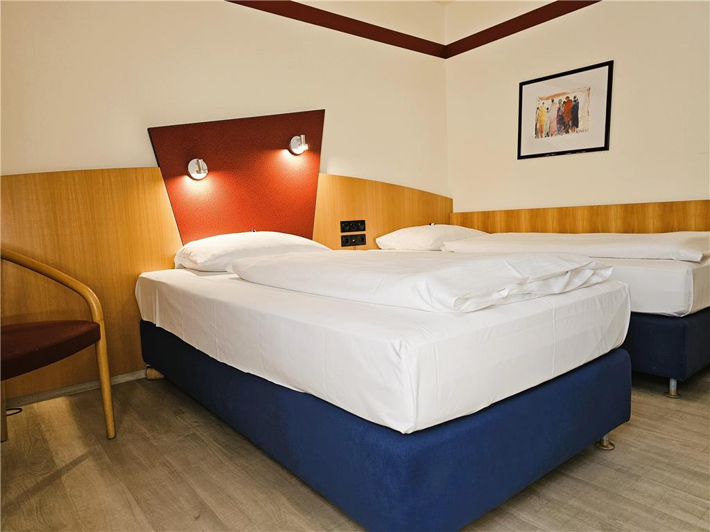 Comfort double room with twin beds, desk, spacious wardrobe, wall mirror, seating, TV, bathroom