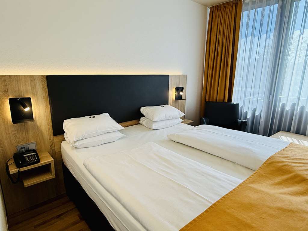 Comfort double room with queen-size bed, desk, spacious wardrobe, wall mirror, seating, TV, bathroom