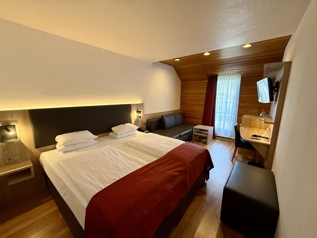 Comfort double room with queen-size bed, desk, spacious wardrobe, wall mirror, seating, TV, bathroom